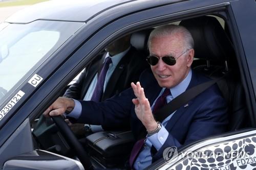 조 바이든 미국 대통령이 18일(현지시간) 미시간주 디어본의 포드 공장을 방문해 곧 출시될 신형 전기차 F-150 라이트닝 픽업트럭을 시승하며 손을 흔들고 있다.
