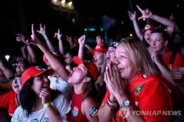 30일(현지시간) 밤 상파울루 파울리스타 대로에서 룰라 당선인 지지자들이 기뻐하며 환호하고 있다.