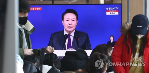 1일 오전 서울역 대합실에서 시민들이 윤석열 대통령의 2023년 신년사 방송을 시청하고 있다.